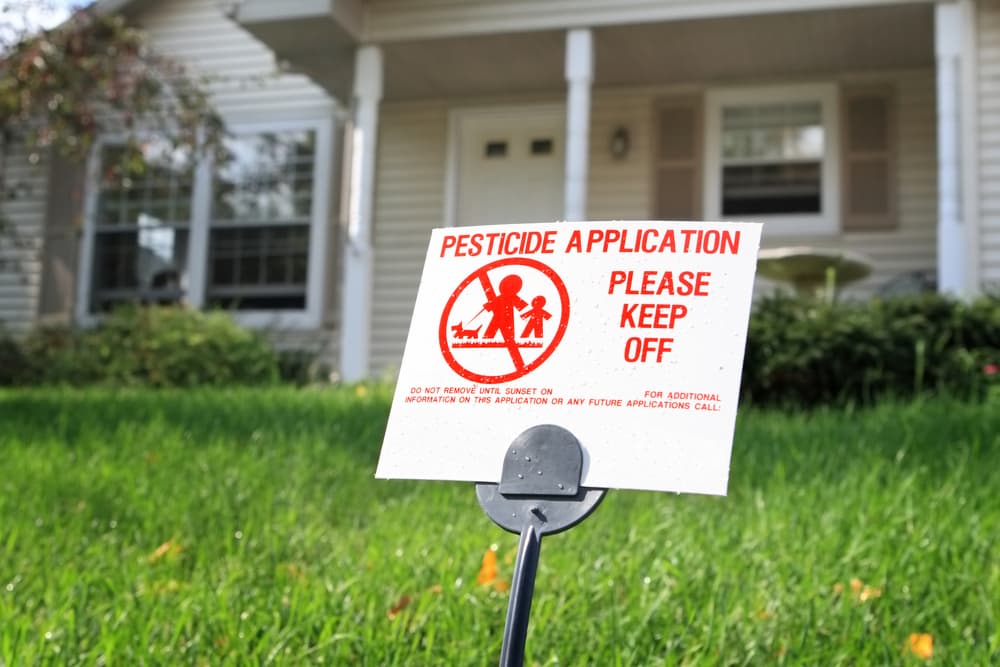 Lawn with sign warning of pesticide treatment